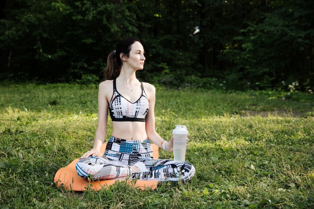 Mujer joven meditando en el parque