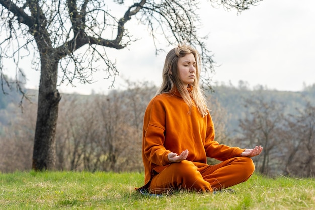 Mujer joven meditando yoga en la montaña Relax y calma