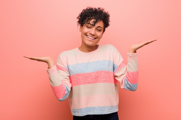 La mujer joven mezclada del adolescente del afroamericano hace escala con los brazos, se siente feliz y confiada.