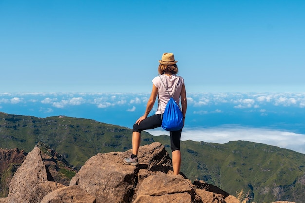 Una mujer joven en el Miradouro do Juncal en Pico do Arieiro y sus montañas Madeira Portugal