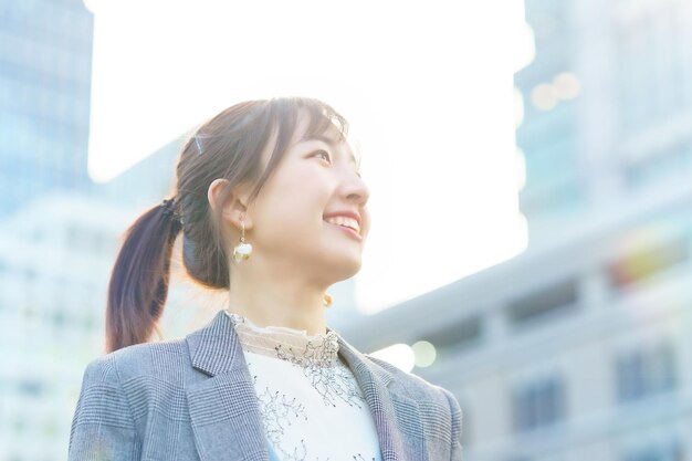 Una mujer joven mirando al cielo en la ciudad.