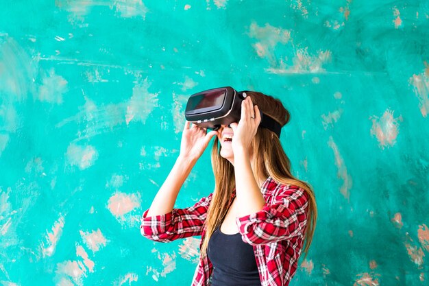 Mujer joven mirando aunque el dispositivo VR.