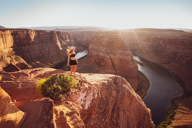 Mujer joven mirando a la curva de la herradura y al famoso lugar de senderismo del río colorado glen canyon arizona usa