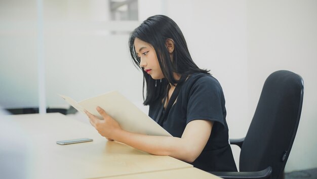 mujer joven mirando el folleto para la promoción de la oficina