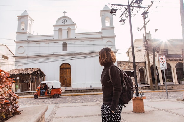 Una mujer joven mirando la iglesia blanca de Copán Ruinas Honduras