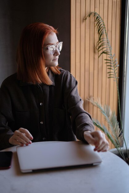 Mujer joven mirando lejos en la cafetería