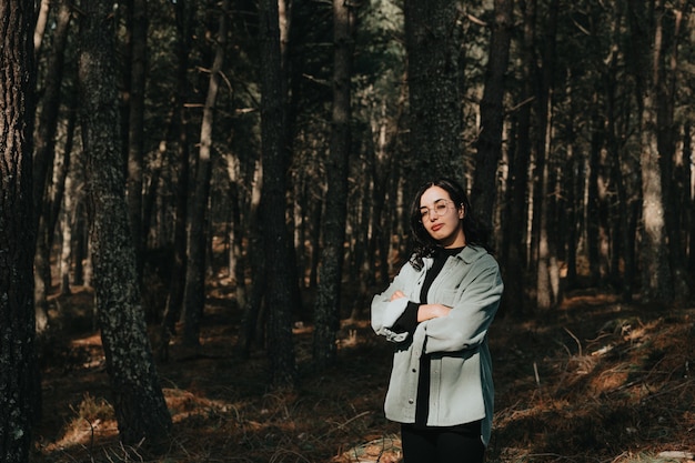 Mujer joven mirando en medio de un bosque de pinos