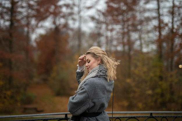 Foto mujer joven mirando hacia otro lado mientras está de pie en el bosque