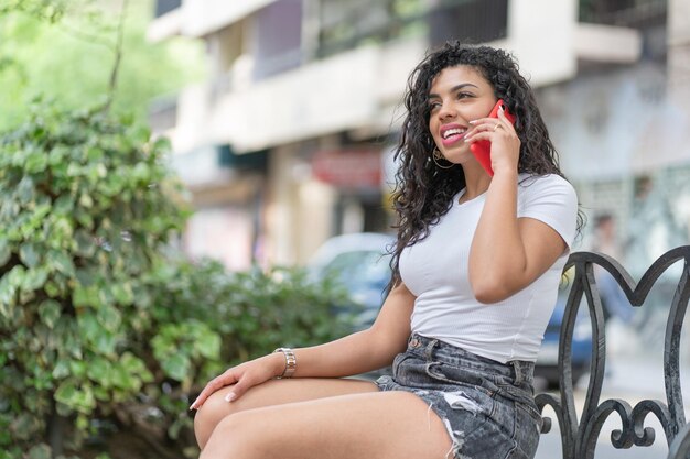 Foto mujer joven mirando hacia otro lado mientras está sentada al aire libre