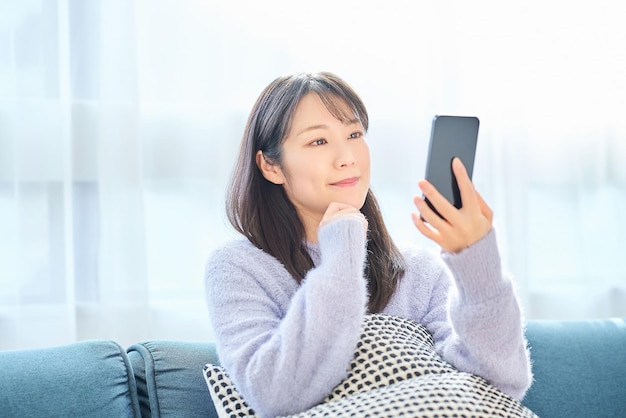 Foto mujer joven mirando la pantalla de su teléfono inteligente