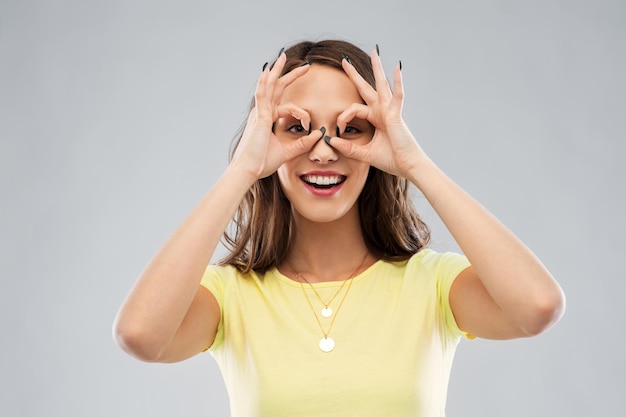 mujer joven mirando a través de gafas de dedos