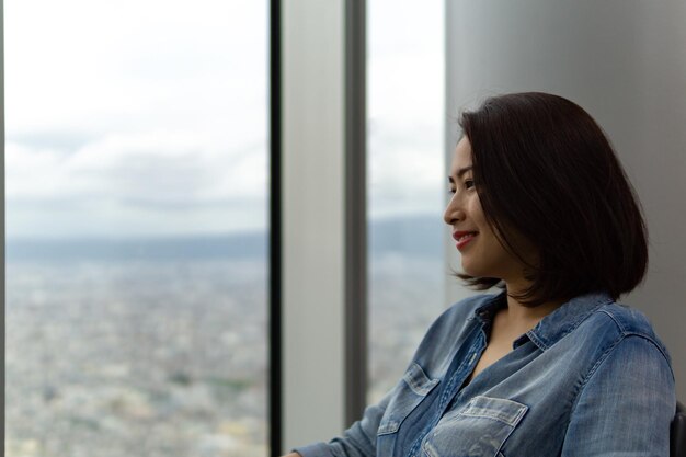 Mujer joven mirando por la ventana