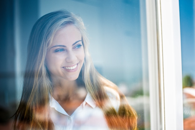 Mujer joven mirando por la ventana