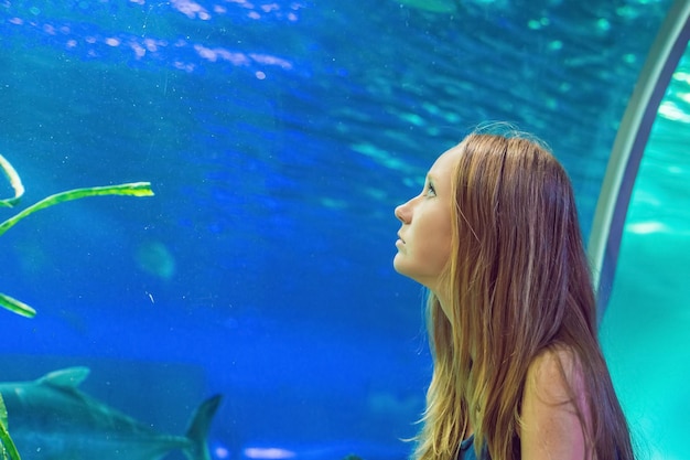 mujer joven, el mirar, pez, en, un, túnel, acuario