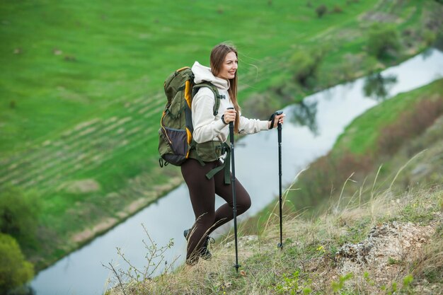 Mujer joven con mochila caminando en las montañas concepto de senderismo trekking acantilados viajero de viaje