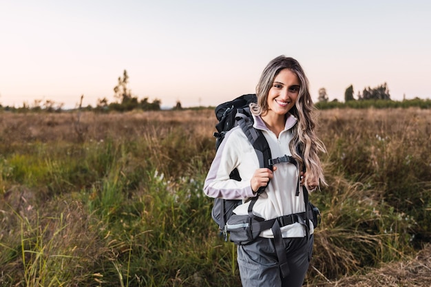 Mujer joven con mochila en medio del campo Nómada digital