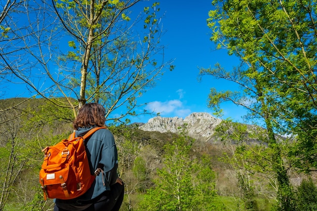 Una mujer joven con una mochila mirando las montañas y el río Sella entre El Tornin a la Olla de San Vicente cerca de Cangas de Onis Asturias España