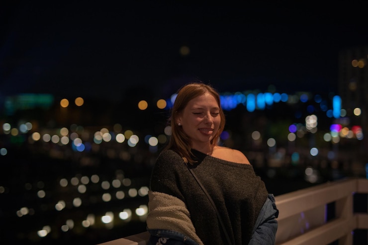 Foto mujer joven a la moda en la ciudad por la noche