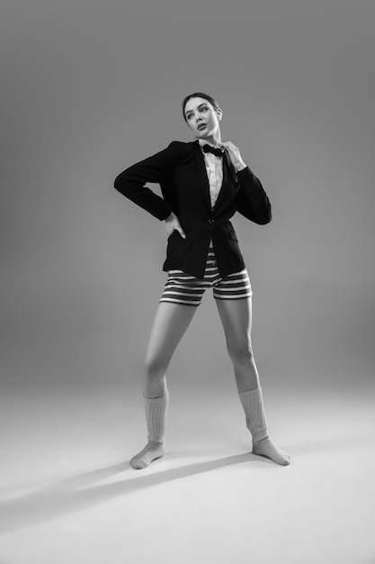 Mujer joven de moda y elegante con chaqueta y calcetines trabajando desde casa.