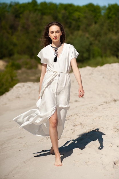 Mujer joven de moda en la playa con camisa blanca