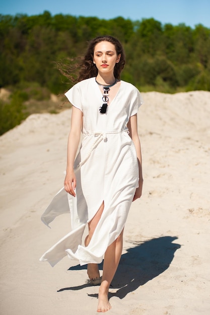 Mujer joven de moda en la playa con camisa blanca