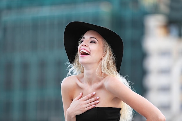 Mujer joven de moda posando en el fondo del edificio