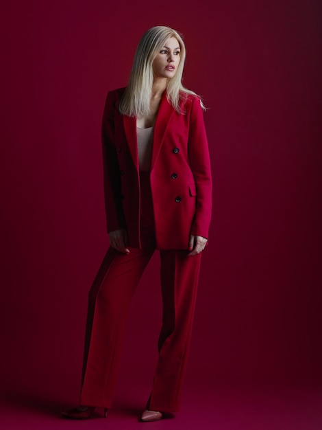 Mujer joven de moda en traje rojo fondo rojo