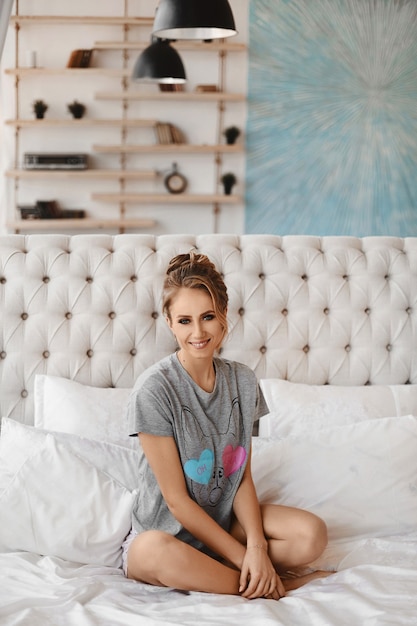 Mujer joven modelo con cuerpo delgado en pijama posando en la cama por la mañana chica guapa posando ...