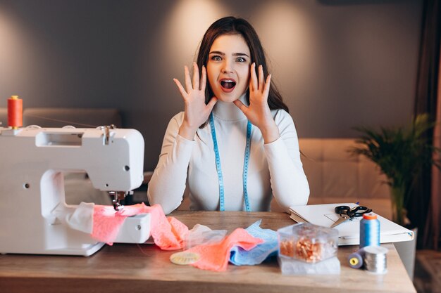 Mujer joven modista con máquina de coser