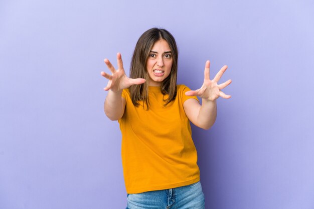 Mujer joven molesta gritando con las manos tensas