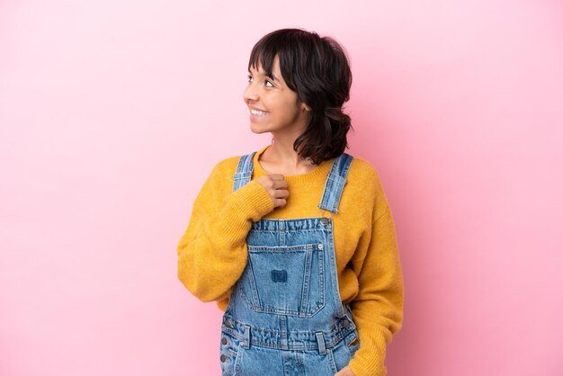 mujer joven, con, monos, aislado, plano de fondo, mirar hacia el lado, y, sonriente