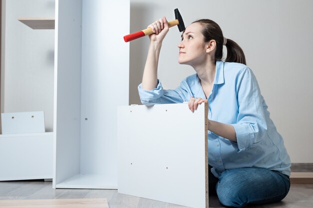 Mujer joven montando muebles