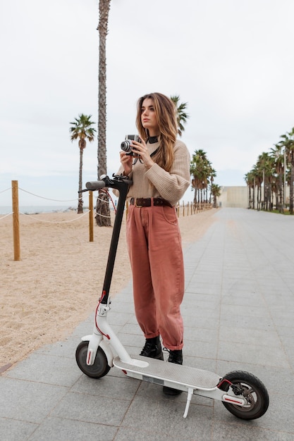 Foto mujer joven montando un scooter eléctrico