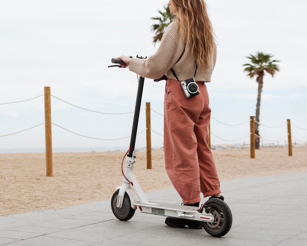 Foto mujer joven montando un scooter eléctrico