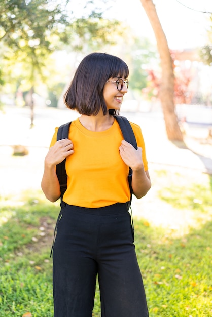 Mujer joven morena al aire libre con expresión feliz