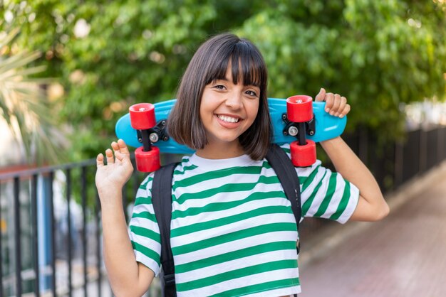 Mujer joven morena al aire libre con un patín