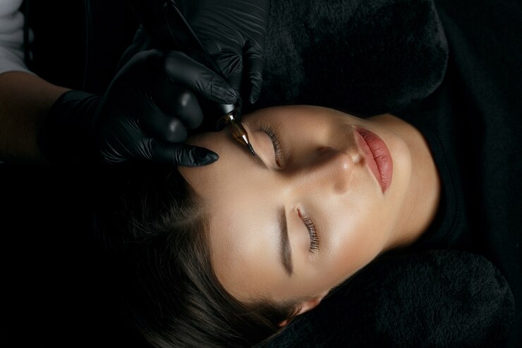 Mujer joven morena con procedimiento permanente de cejas en el salón de belleza. Vista superior
