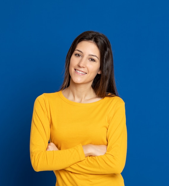 Mujer joven morena que gesticula sobre la pared azul