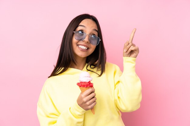 Mujer joven morena sosteniendo un helado de cucurucho aislado