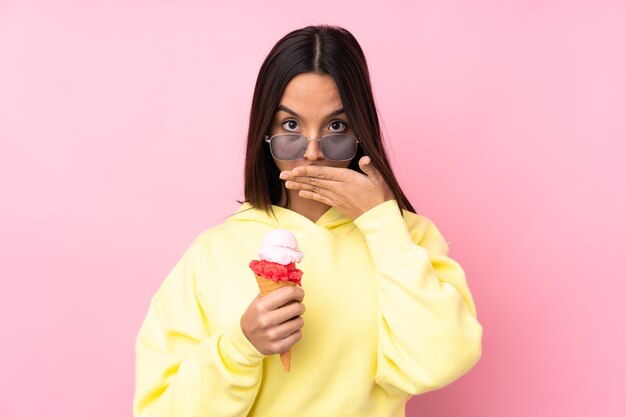 Mujer joven morena sosteniendo un helado de cucurucho aislado