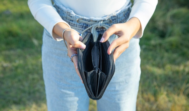 Foto mujer joven mostrando la billetera vacía crisis