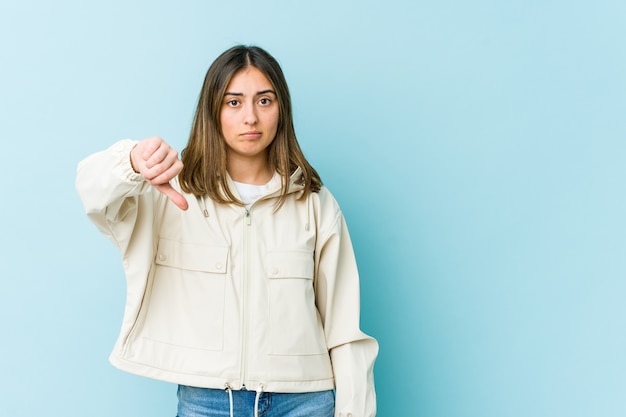 Mujer joven mostrando un gesto de aversión, pulgares hacia abajo