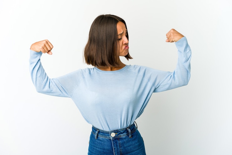 Foto mujer joven mostrando gesto de fuerza con los brazos