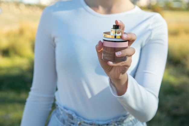 Mujer joven mostrando perfume Belleza Moda