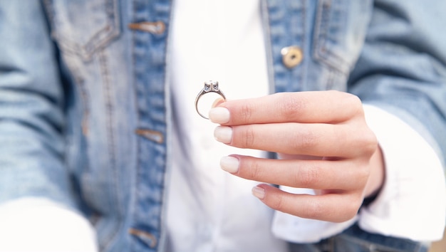 Mujer joven mostrando su anillo de compromiso.