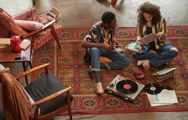 Mujer joven mostrando su disco de vinilo favorito a su novio afroamericano