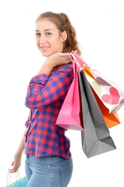 Mujer joven con muchas bolsas de compras en blanco