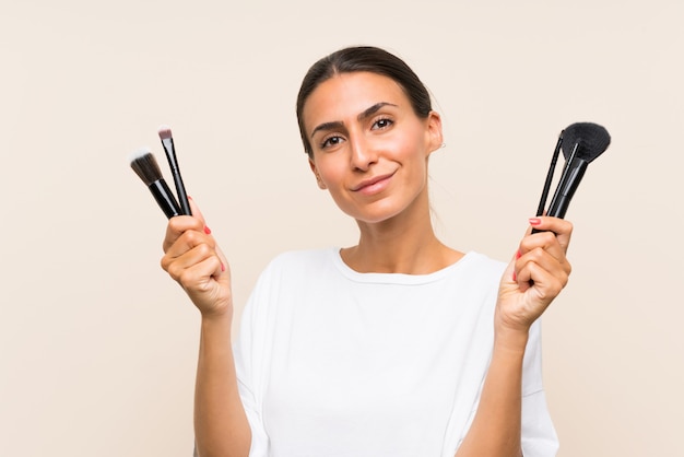 Mujer joven con mucho pincel de maquillaje