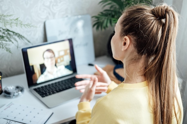 Mujer joven, mujer de negocios, estudiante, maestra, tutora, haciendo llamadas de video virtuales en línea, independiente.