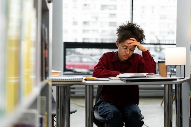 Foto mujer joven multirracial ansiosa que se siente cansada mientras estudia en la escuela chica preocupada y estresada haciendo un examen que no sabe las respuestas